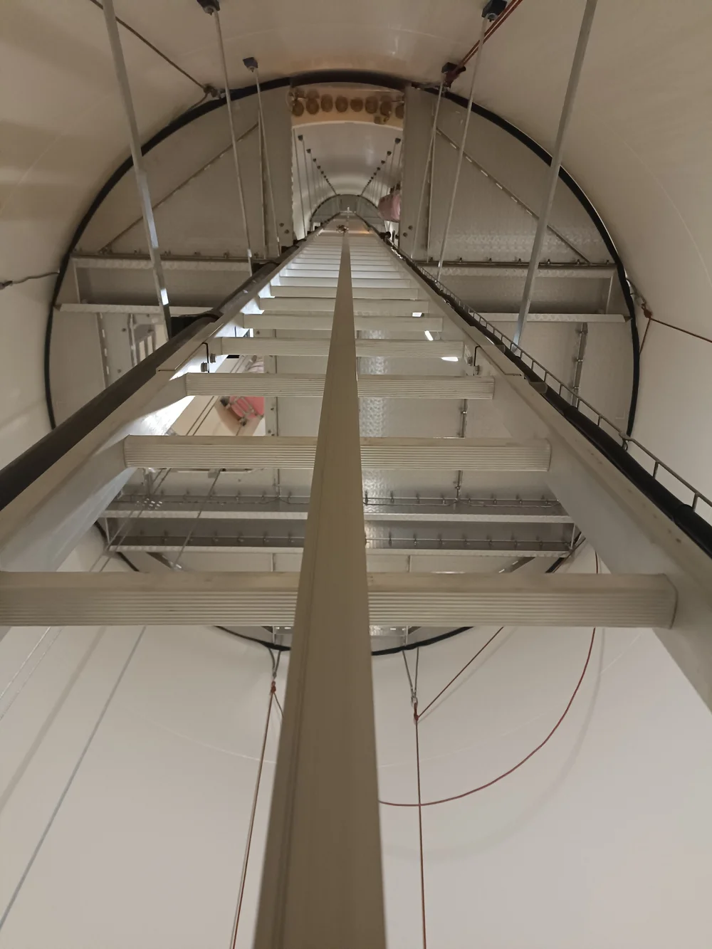 Interior de torre eólica con escalera y líneas de seguridad