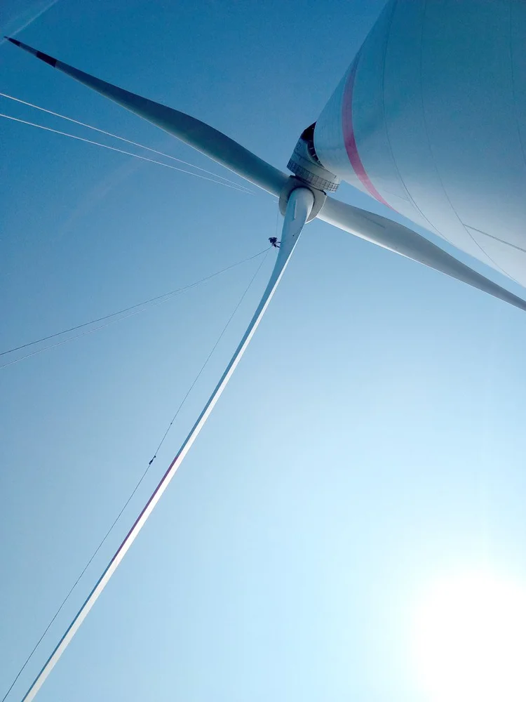 Técnico en acceso por cuerdas bajo un aerogenerador